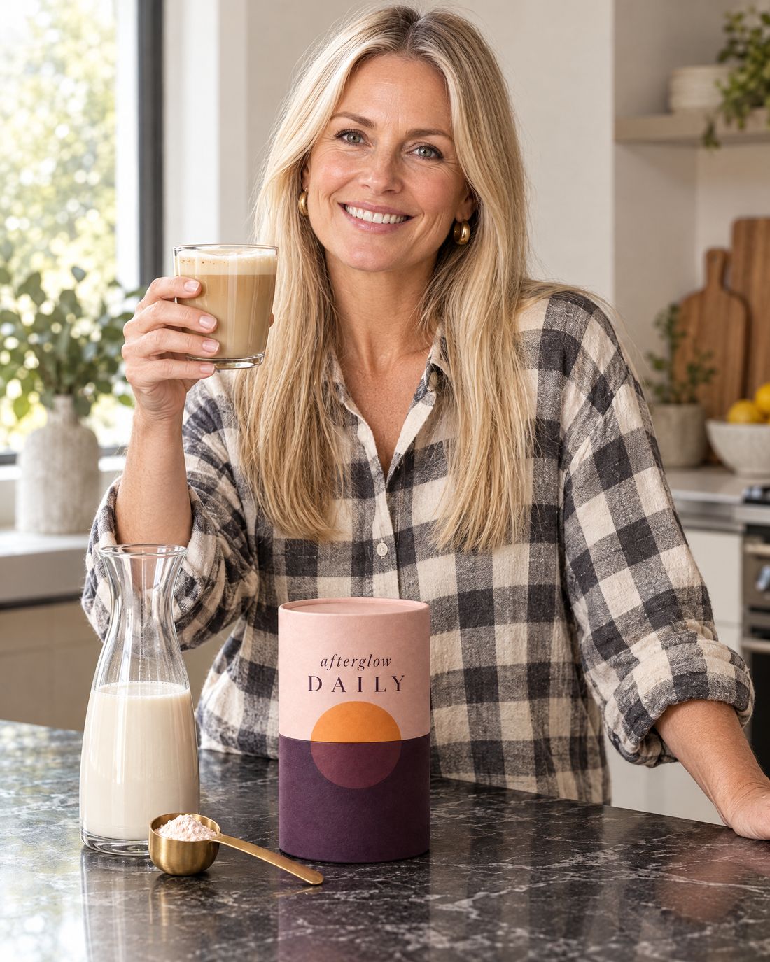 A smiling woman with her coffee and the Afterglow tub at the kitchen counter